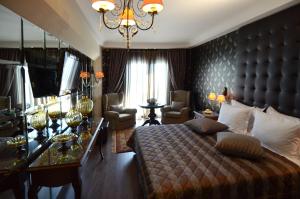 a bedroom with a large bed and a chandelier at Danai Hotel & Spa in Olympic Beach