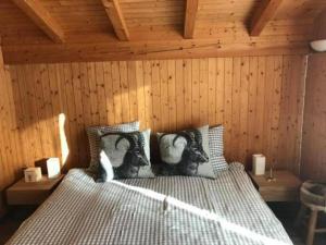 ein Schlafzimmer mit einem Bett in einer Holzwand in der Unterkunft Chalet Toggi in Wildhaus