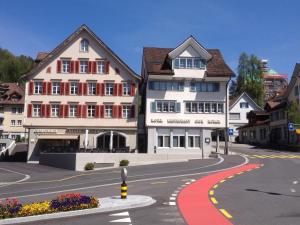 un grand bâtiment blanc sur le côté d'une rue dans l'établissement Café-Conditorei Hotel Huber, à Lichtensteig