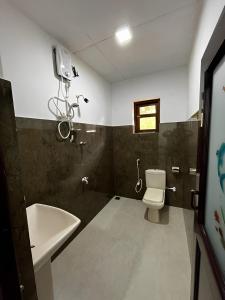 a bathroom with a toilet and a sink at Water Front Home Stay in Anuradhapura