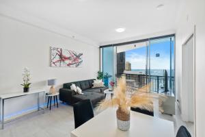 黃金海岸的住宿－2 Bedroom Beach View Apartment in Surfers Paradise! Free Parking & Wifi，客厅配有沙发和桌子