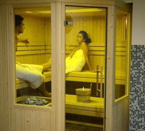 a man and woman sitting in a sauna at Danai Hotel & Spa in Olympic Beach