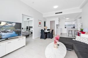 a living room with a couch and a tv at 2 Bedroom Beach View Apartment in Surfers Paradise! Free Parking & Wifi in Gold Coast