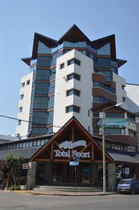 un edificio alto con un hotel detrás de un edificio en Apartamentos Cardinal Bariloche en San Carlos de Bariloche