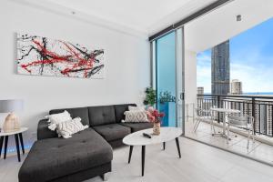 a living room with a couch and a table at 2 Bedroom Beach View Apartment in Surfers Paradise! Free Parking & Wifi in Gold Coast