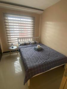 Un dormitorio con una cama y una ventana con una vela. en Lovely Condo in CEBU (W/ Car Rental - Inquire) en Cebú