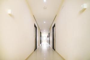 an empty corridor in an office building with white walls at Flagship Vj Inn Nagamalli Thota in Kākināda