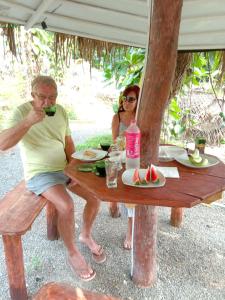 un hombre y una mujer sentados en una mesa de picnic en My House Ahangama en Ahangama