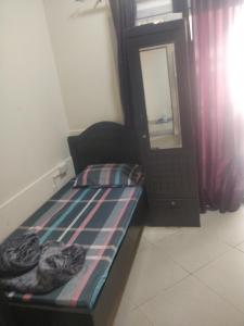 ein kleines Schlafzimmer mit einem Bett und einem Spiegel in der Unterkunft Furnished Apartment in Dubai