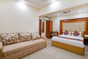 a bedroom with a bed and a couch at FabExpress Alive in Mumbai