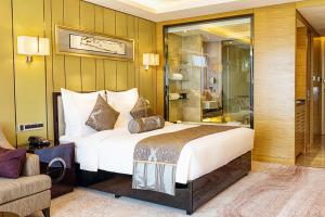 a hotel room with a large bed and a couch at Pullman Wuxi New Lake in Wuxi