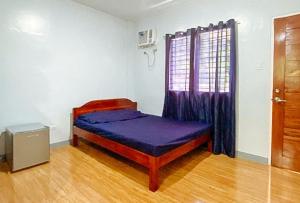 - une chambre avec un lit violet dans l'établissement Irah's Guest House, à Banhigan