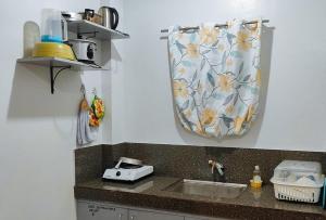 - une cuisine avec un évier et un rideau sur le mur dans l'établissement Irah's Guest House, à Banhigan