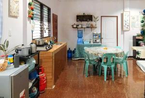 a kitchen with a table and chairs in a room at Irah's Guest House RedPartner in Banhigan