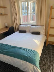 a bedroom with a large white bed with a window at Peaceful 3 BR Flat with A View Near Hospitals-Free Parking in Newcastle under Lyme