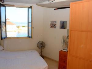 een slaapkamer met een bed, een raam en een ventilator bij Appartement Port Barcarès, 3 pièces, 4 personnes - FR-1-431-126 in Le Barcarès