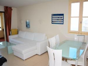 een woonkamer met een witte bank en een glazen tafel bij Appartement Port Barcarès, 3 pièces, 4 personnes - FR-1-431-126 in Le Barcarès