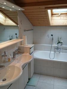 a bathroom with two sinks and a bath tub at Ferienwohnung Mänimatte in Frutigen