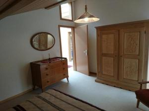 1 dormitorio con tocador y espejo en la pared en Ferienwohnung Mänimatte en Frutigen