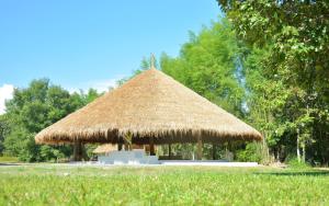 a large hut with a straw roof in a field at resort hoshihana in Chiang Mai