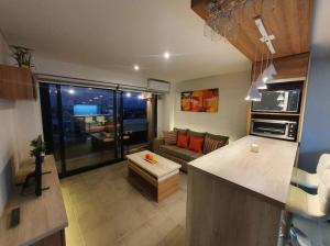 a kitchen and a living room with a couch at Acogedor Departamento Vista a Cordillera in Godoy Cruz