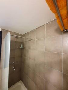 a bathroom with a shower with a tiled wall at Acogedor Departamento Vista a Cordillera in Godoy Cruz +41 photos