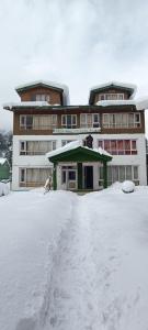 un edificio con mucha nieve delante en New Snow View Resort pahalgam, en Pahalgām