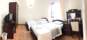 Giường trong phòng chung tại Le Petit Paris Dalat Hotel