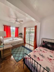 a bedroom with two beds and red curtains at Casa Osmena, Culion in Culion Reservation
