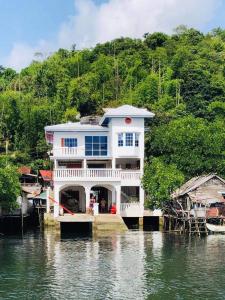 a large house on a dock in the water at Casa Osmena, Culion in Culion