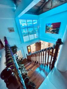a staircase in a house with blue walls and windows at Casa Osmena, Culion in Culion