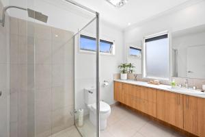 a bathroom with a shower and a toilet and a sink at Aerial Beach House 2 in Torquay +7 photos