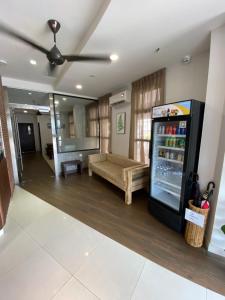 uma sala de estar com um banco e um frigorífico em D'Green Hotel Kuching em Kuching