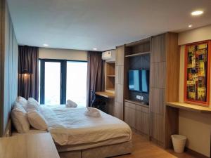 ein Schlafzimmer mit einem Bett und einem TV. in der Unterkunft ekocheras duplex suites with balcony, drinking water, Karaoke K in Kuala Lumpur