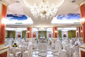 una sala banchetti con tavoli, sedie e lampadario a braccio di Parco dei Principi Hotel a Roccella Ionica Altre 37 foto