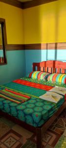 a bedroom with a bed with a colorful bedspread at ALFA Beach Front Lodge in El Nido