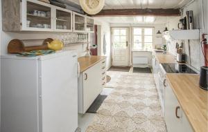 a kitchen with white cabinets and white appliances at 2 Bedroom Awesome Home In Samsø in Nordby