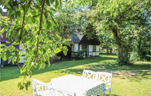 a white table and chairs sitting in the grass at 2 Bedroom Awesome Home In Samsø in Nordby +10 photos