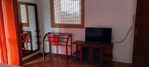 Habitación con TV y mesa con espejo. en HIRU VILLA, en Athurugiriya