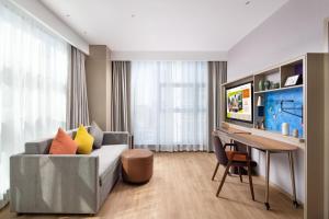 a living room with a couch and a desk at Home2 Suites by Hilton Chongqing Yubei in Chongqing
