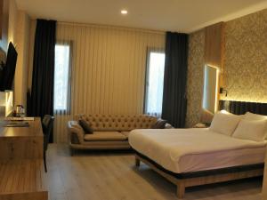 アンタルヤにあるIsnova Hotel Airportのベッドとソファ付きのホテルルーム