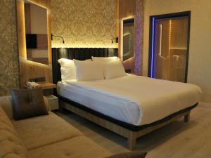 a bedroom with a large bed and a chair at Isnova Hotel in Antalya