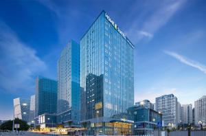 un edificio alto con molte finestre in una città di Home2 Suites by Hilton Chongqing Yubei a Chongqing