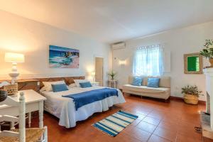 a large bedroom with a bed and a couch at Hotel-Apart CORTIJO LAS PIÑAS in Tarifa