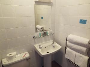 a white bathroom with a sink and a mirror at Maluth Lodge in Great Yarmouth +45 photos