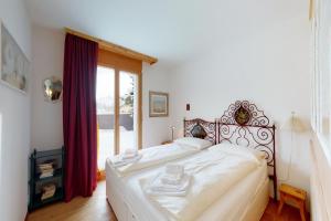a bedroom with a large bed with a large window at Apartment Sur Puoz 2A in Samedan