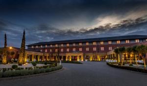 een groot rood gebouw met 's nachts een binnenplaats bij Castletroy Park Hotel in Limerick