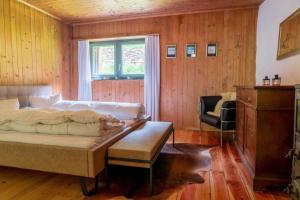um quarto com uma cama, uma cadeira e uma janela em Sunny, rustical 5 room cottage in Valposchiavo em Poschiavo