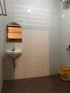 ein Bad mit einem Waschbecken und einem Fenster in der Unterkunft Griya Lathifah Homestay in Kalasan