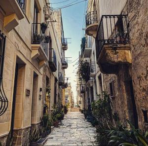 une ruelle étroite avec des bâtiments et des plantes dans une ville dans l'établissement Malta Suites, à Isla